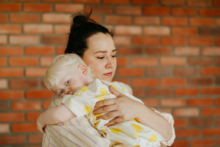 Woman holding child looking worried